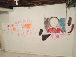 portrait painted on basement wall by kids during painting party before demolishing old house